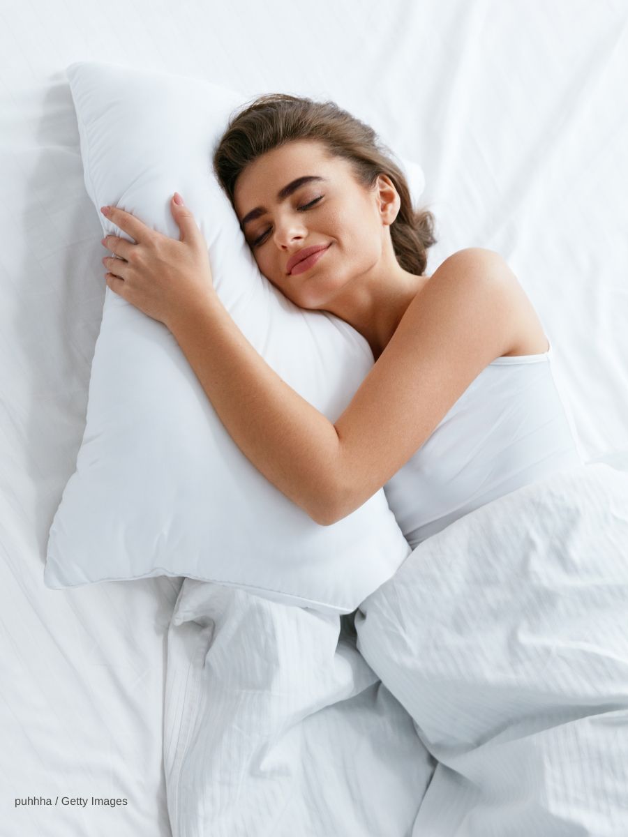 Eine Frau liegt glücklich im Bett
