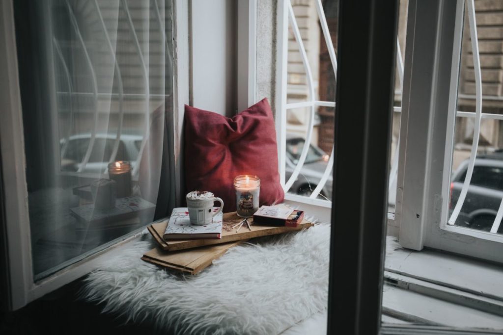 sitting on the window with a book and a coffee